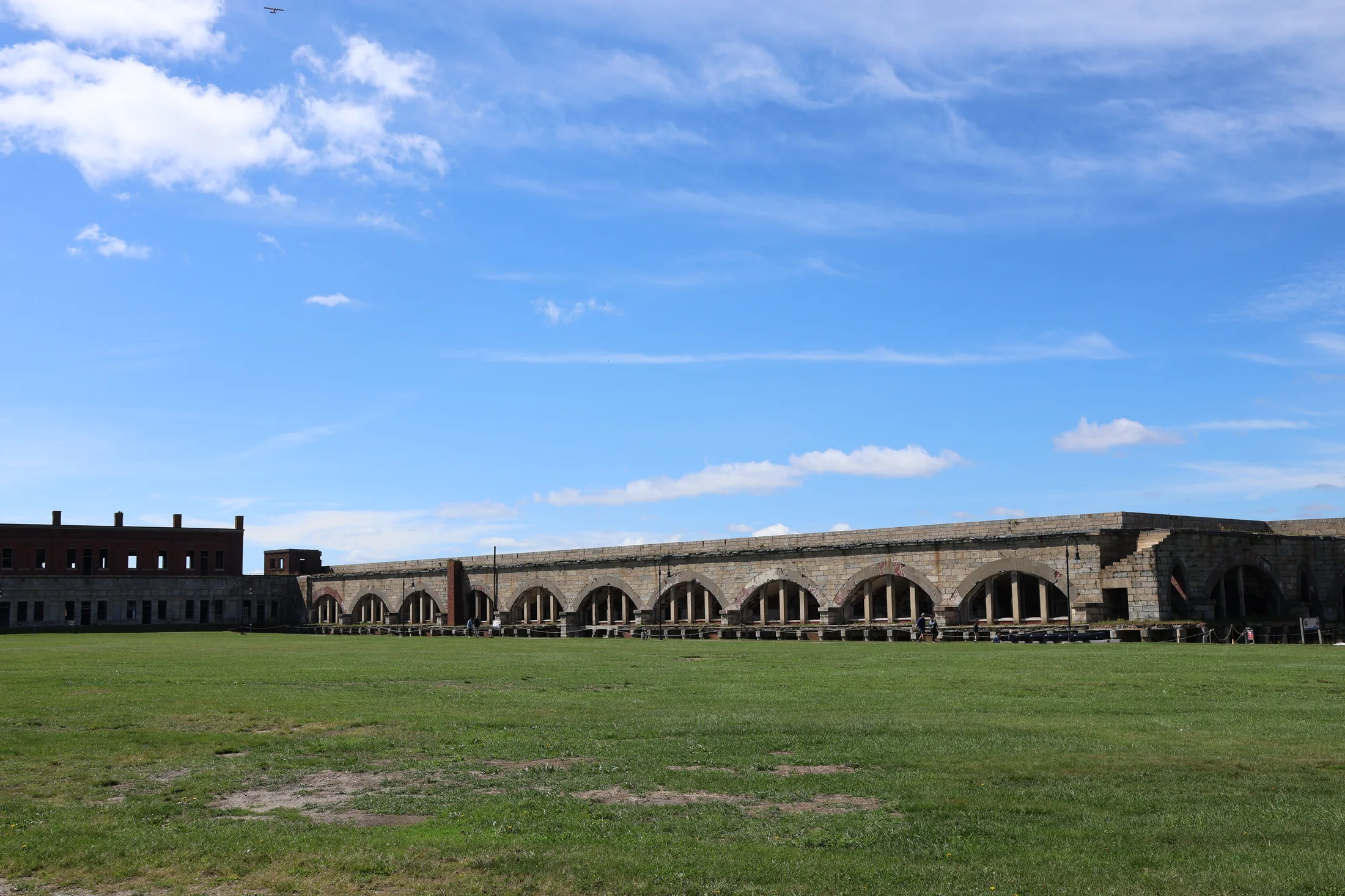 The green parade field framed by Fort Adams’ stone walls beneath a blue sky